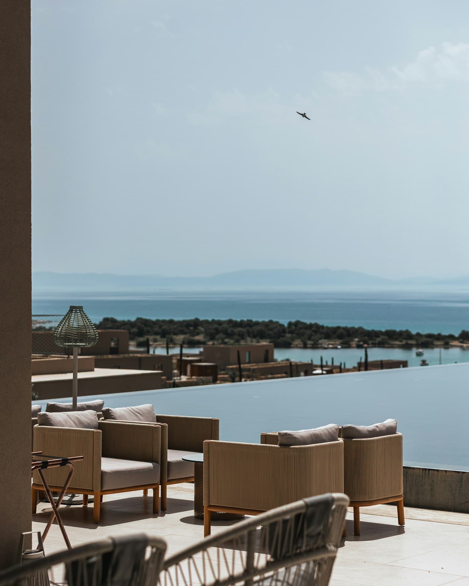 Pool terrace with rattan chairs overlooking the sea