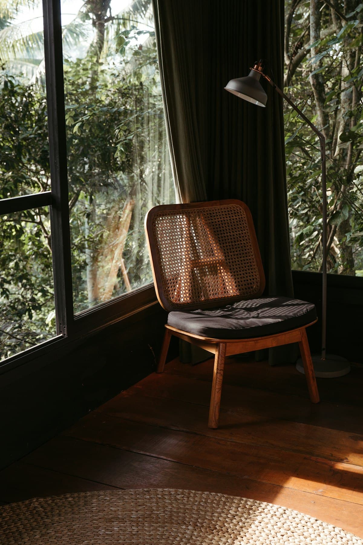 Rattan chair beside a window overlooking the jungle